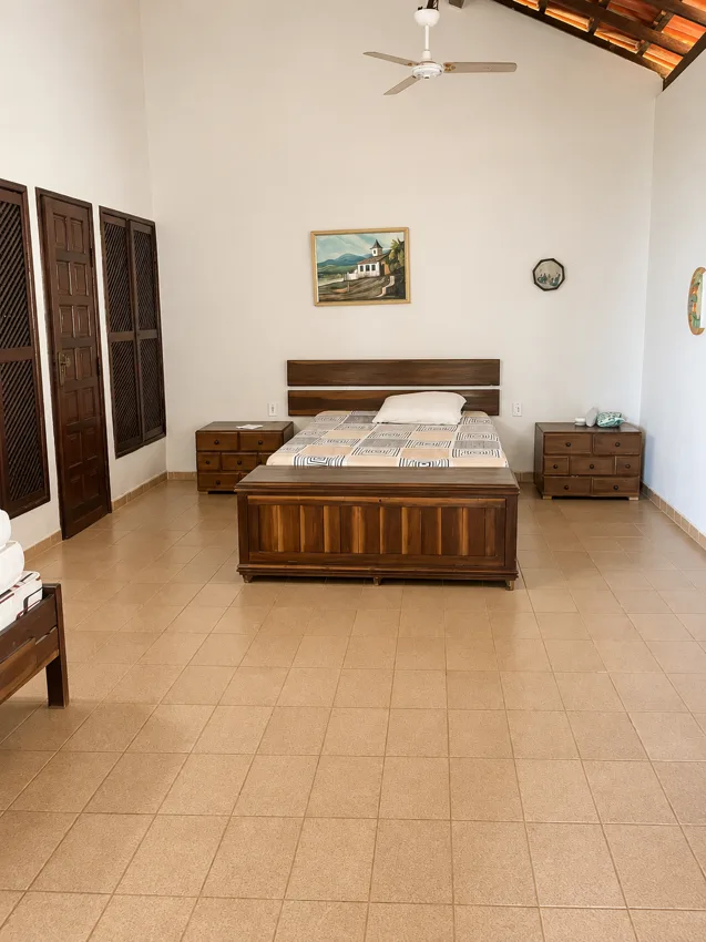 Quarto amplo com cama de madeira